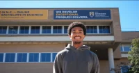 MBA student in front of the Bryan School