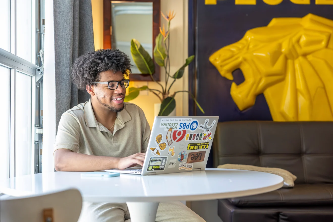 UNCG Bryan School online student doing work on a laptop 